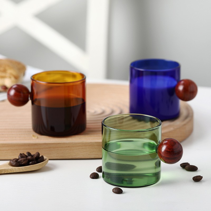 Fargerik kreativ kaffekopp med kulehåndtak av tre